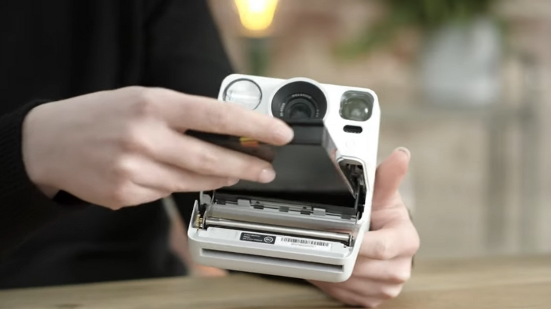 A Person Inserting a Film Pack Into a Polaroid Camera